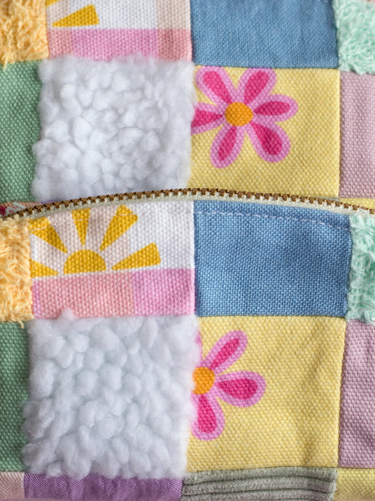 Close up details of multi-coloured patchwork made up of different printed and textures fabrics. 