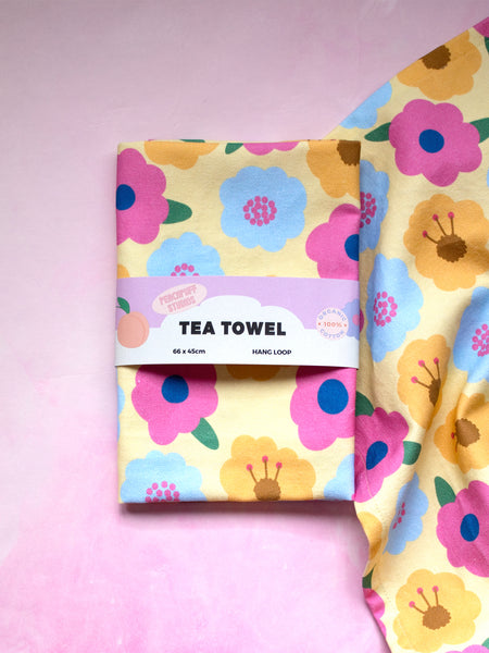 a yellow and colourful floral printed tea towel wrapped in a fun and creative belly band.