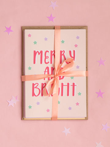 A pack of Christmas cared tied together with a peach coloured ribbon.