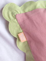 A close-up of a pink cushion shows the detail scalloped trim details.