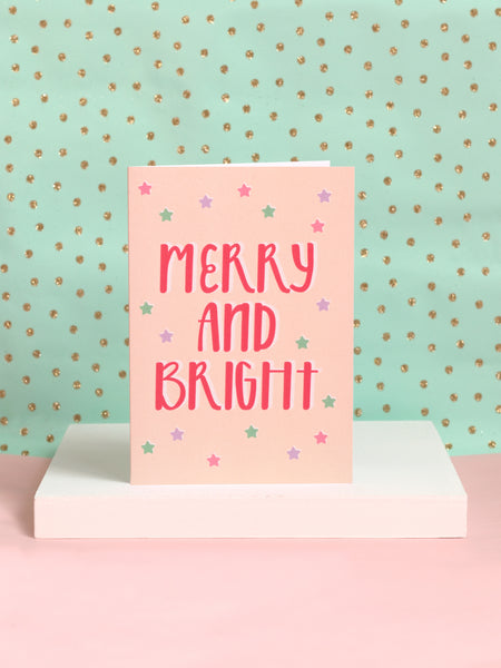 A Christmas card with 'merry and bright' written in modern typography on a white block.