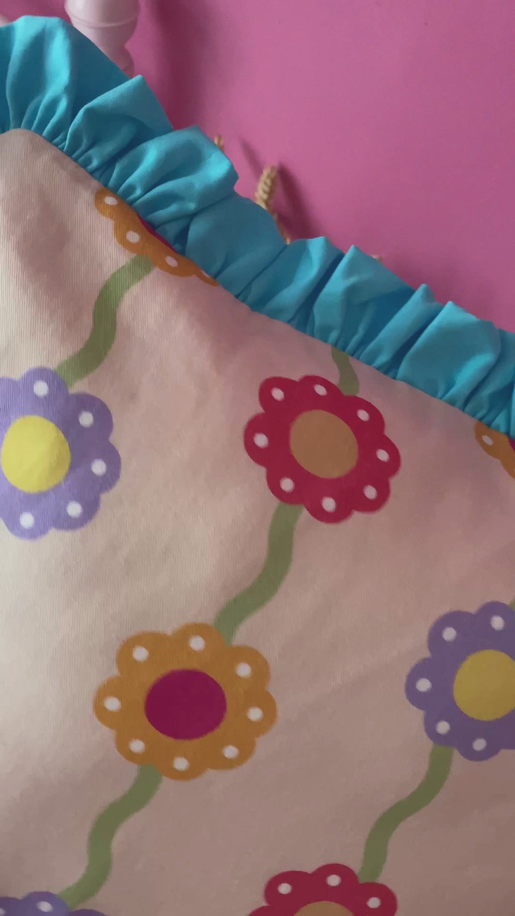 A pink floral printed cushion with blue ruffles is opened by the concealed zip and shows close-ups of fabric details.