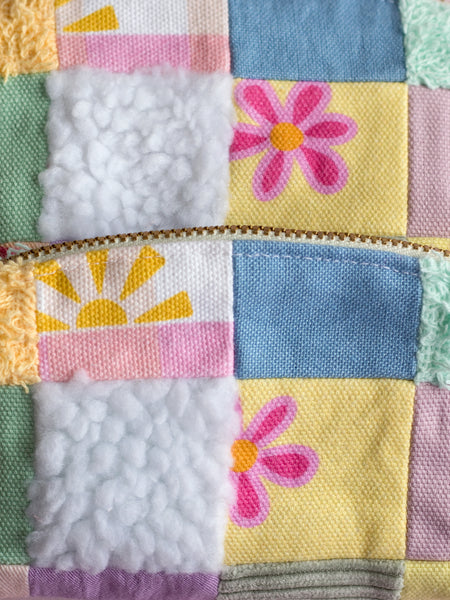 Close up details of multi-coloured patchwork made up of different printed and textures fabrics. 