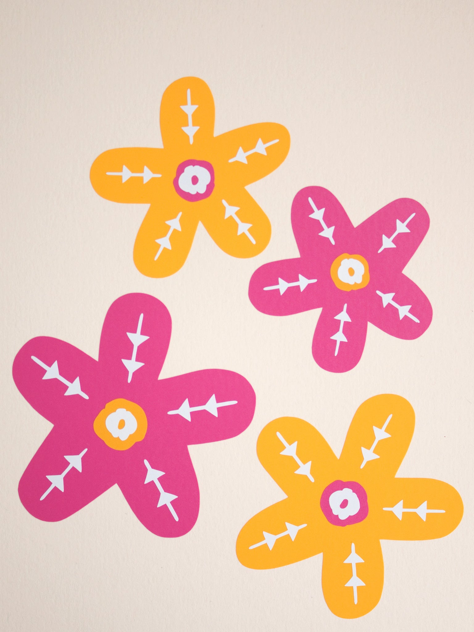 An art print of two orange and two pink flowers. Each flower is of a different size and decorated with white details.