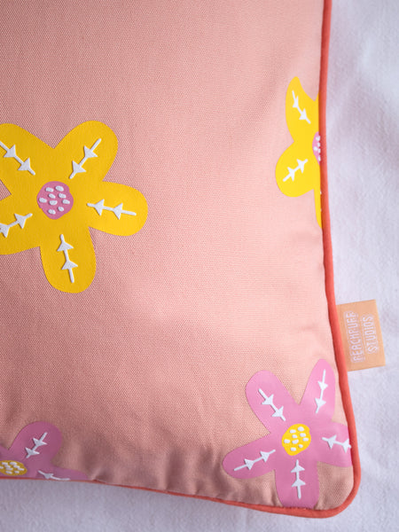 A close-up of a dusty pink cushion cover shows the pink and yellow vinyl flowers and piping details.