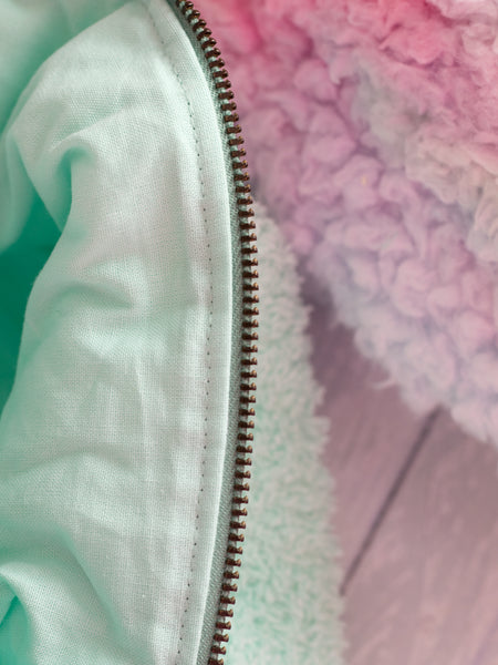 A close-up detail of a mint green towelling makeup bag with a mint green lining.