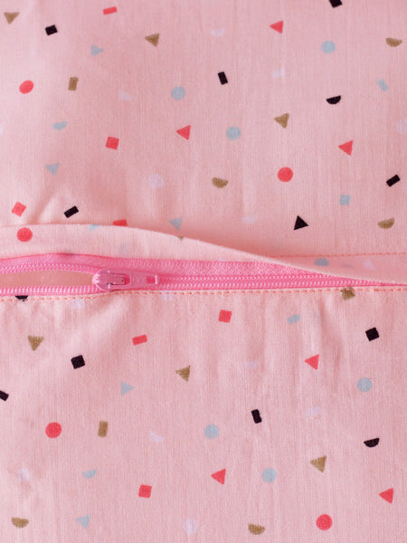 A close-up of a pink cushion with pastel dots shows the back zip details.