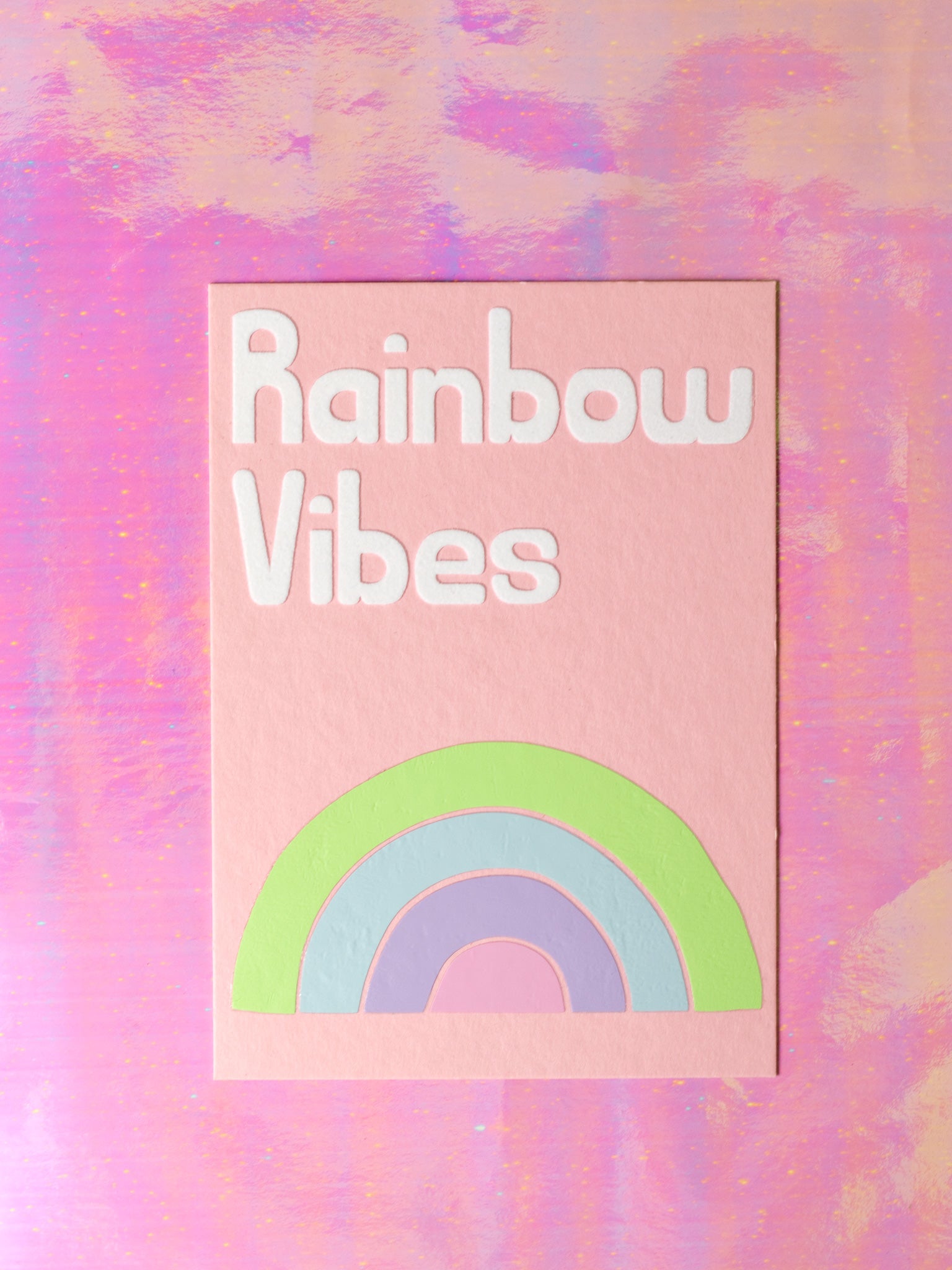 Art print with Rainbow Vibes in flocked font written on top of a drawn rainbow made up of four stripes of colour.