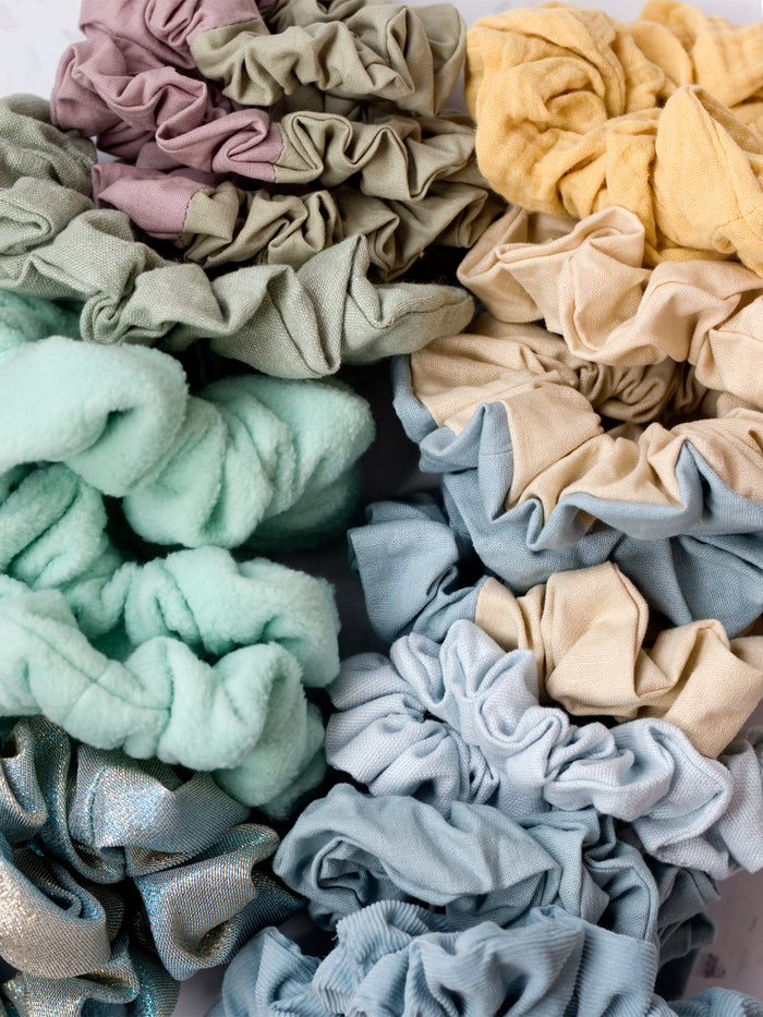 Two diagonal rows of scrunchies in yellow, blue and green colours.