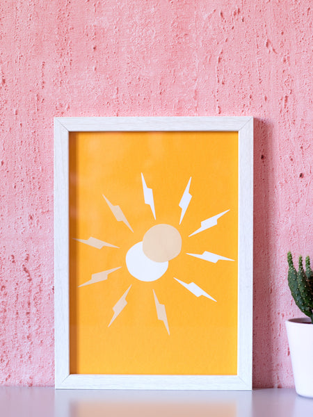 A framed art print of a simple beige and white sun with thunderbolt rays overlapping in front of a pink textured wall.