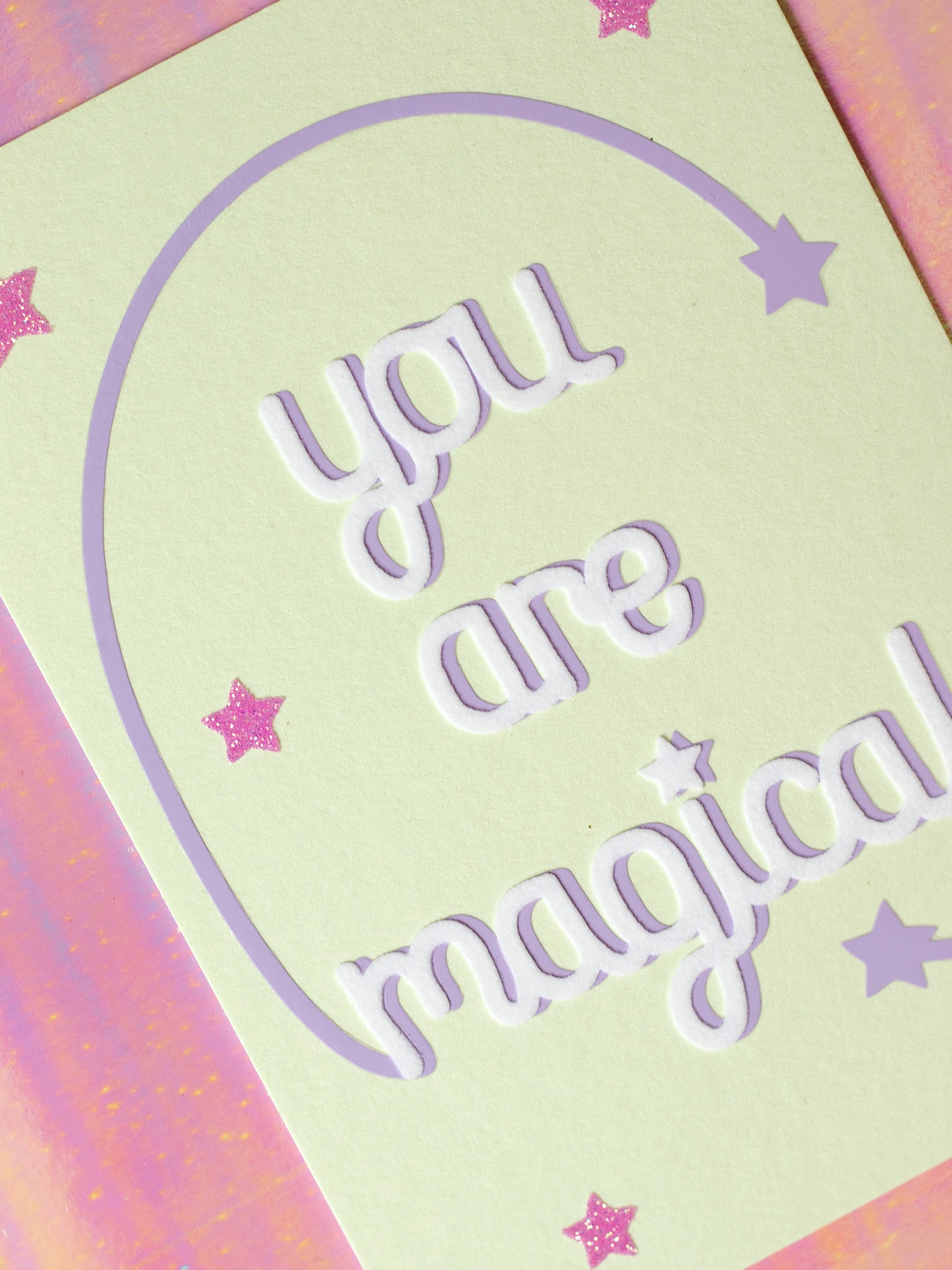 Art print with You Are Magical in flocked font with a purple curved line with a star at the end, coming off with M and L of magical. 
